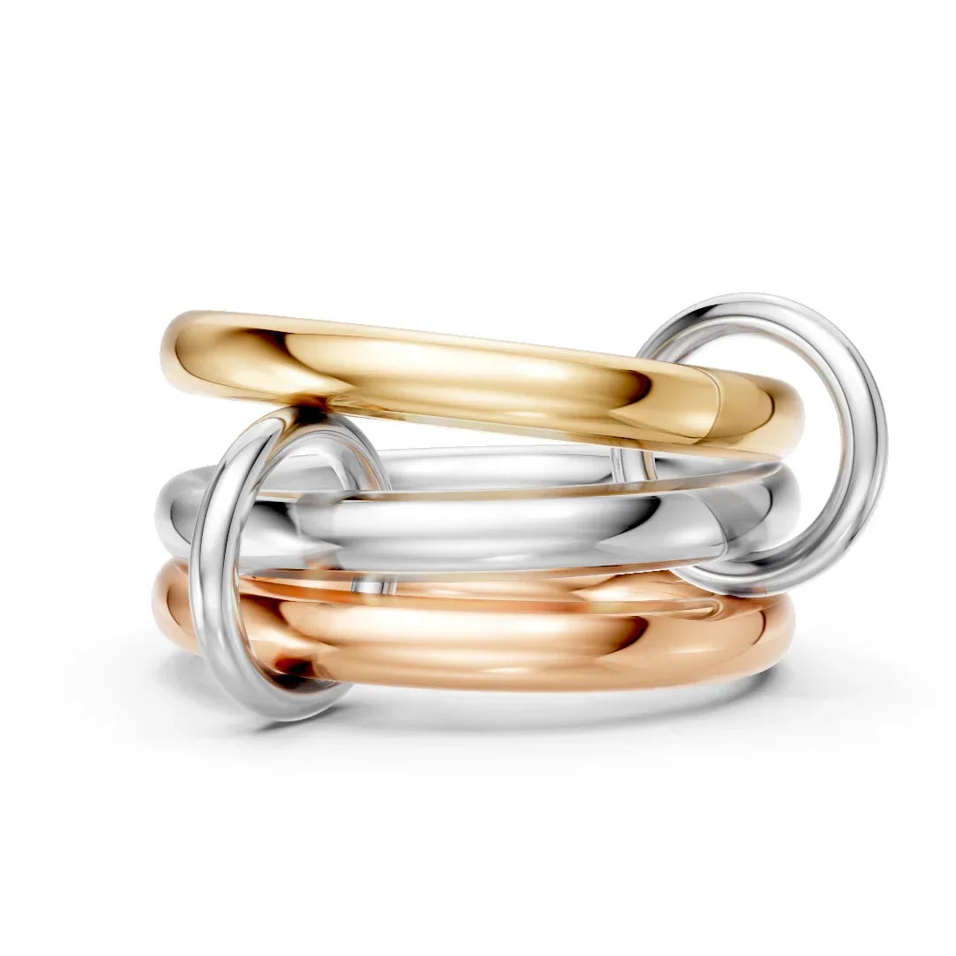 Stacked mixed metal rings in yellow gold, white gold, and rose gold on white background