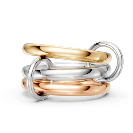 Stacked mixed metal rings in yellow gold, white gold, and rose gold on white background