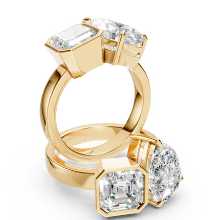 Custom gold engagement rings with large square and pear-shaped diamonds on white background