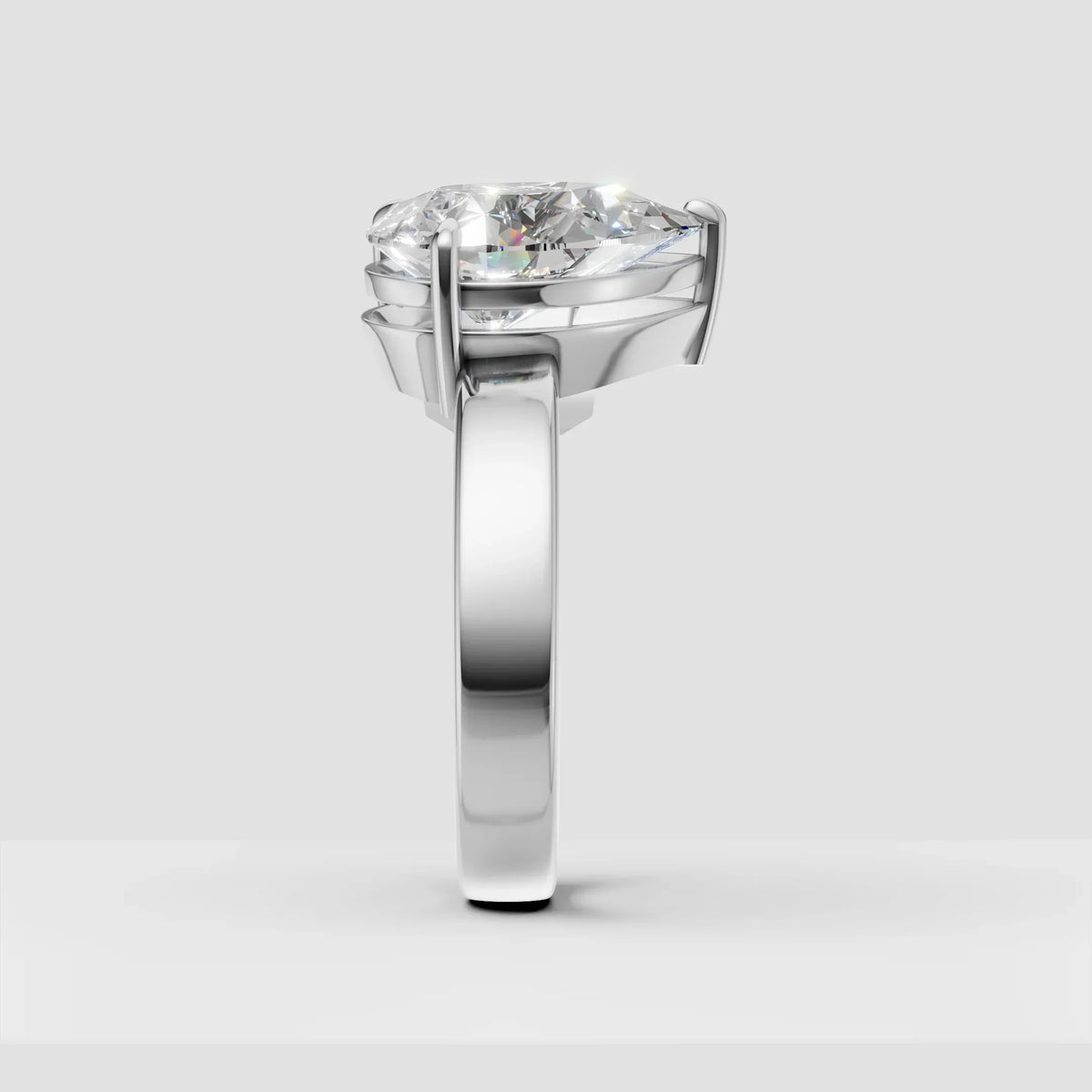 Side view of a solitaire diamond engagement ring with a polished white gold band