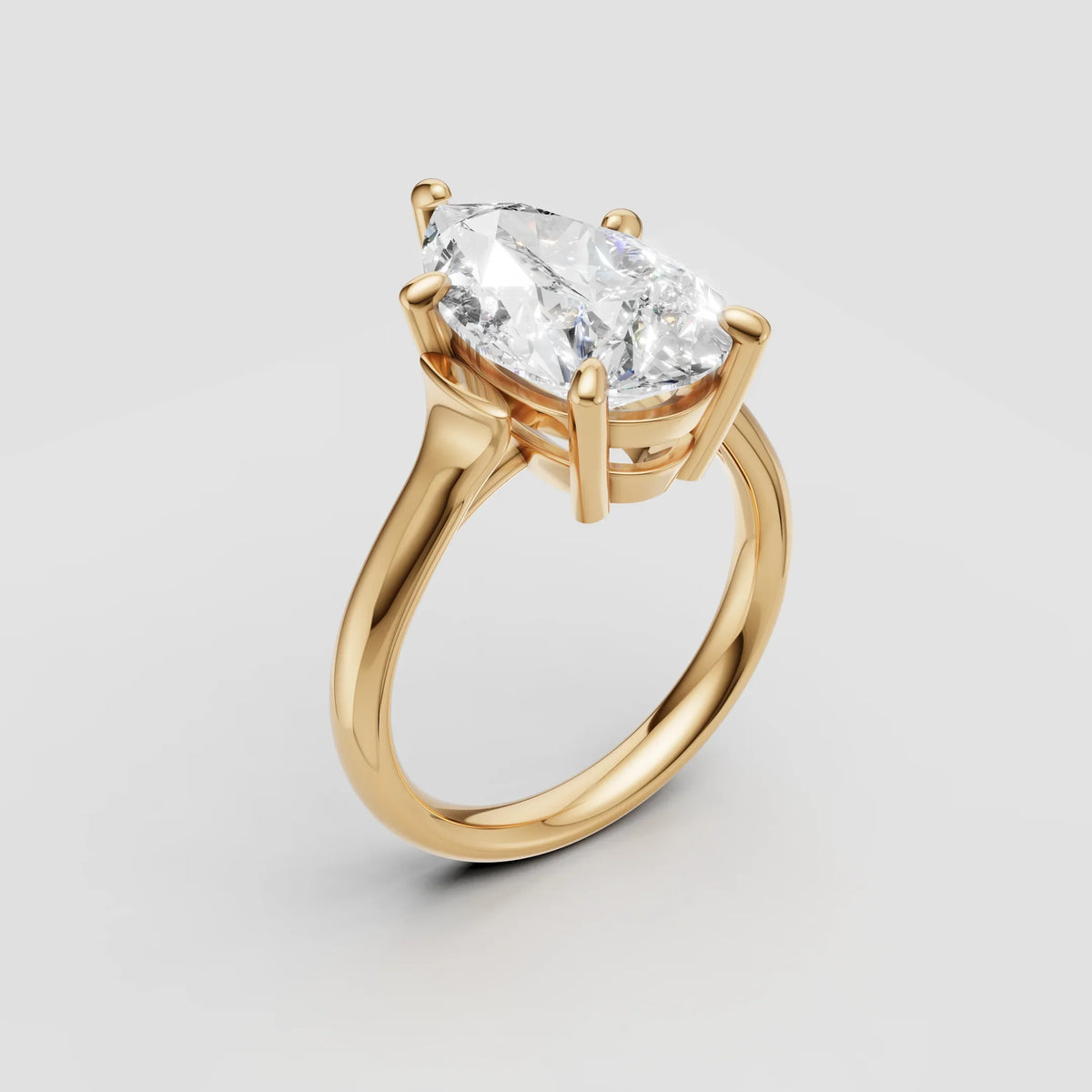 Marquise cut diamond engagement ring in yellow gold solitaire setting on white background
