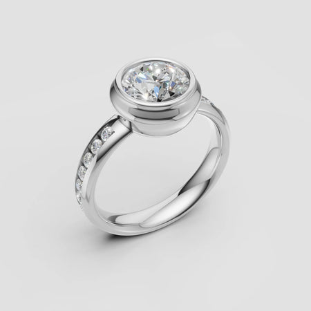 White gold engagement ring with bezel-set round diamond and diamond-accented band