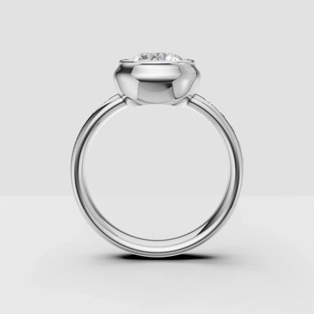 Platinum solitaire engagement ring with round diamond bezel setting on white background