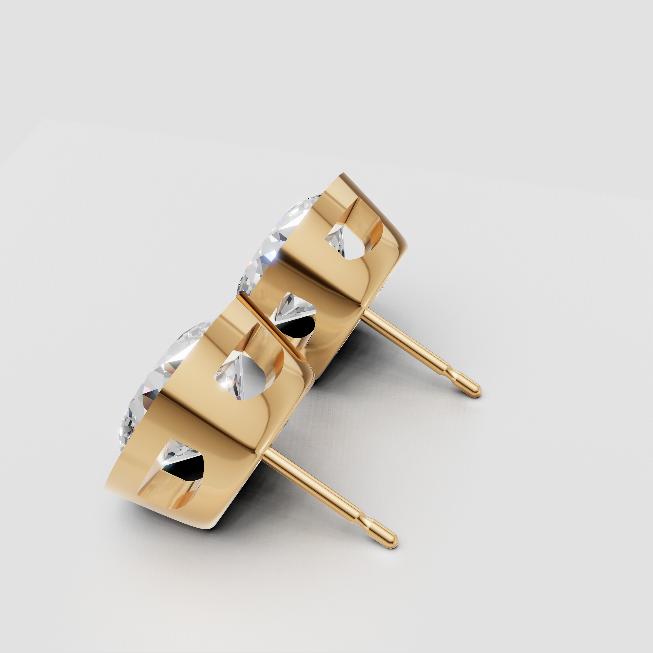 Gold stud earrings with round-cut diamonds in bezel settings on white background