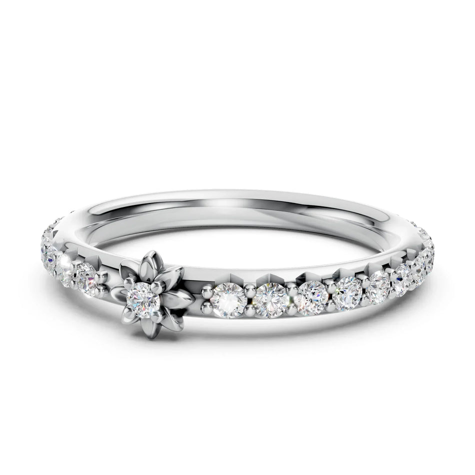 Silver flower engagement ring with a central diamond and pavé diamond band.