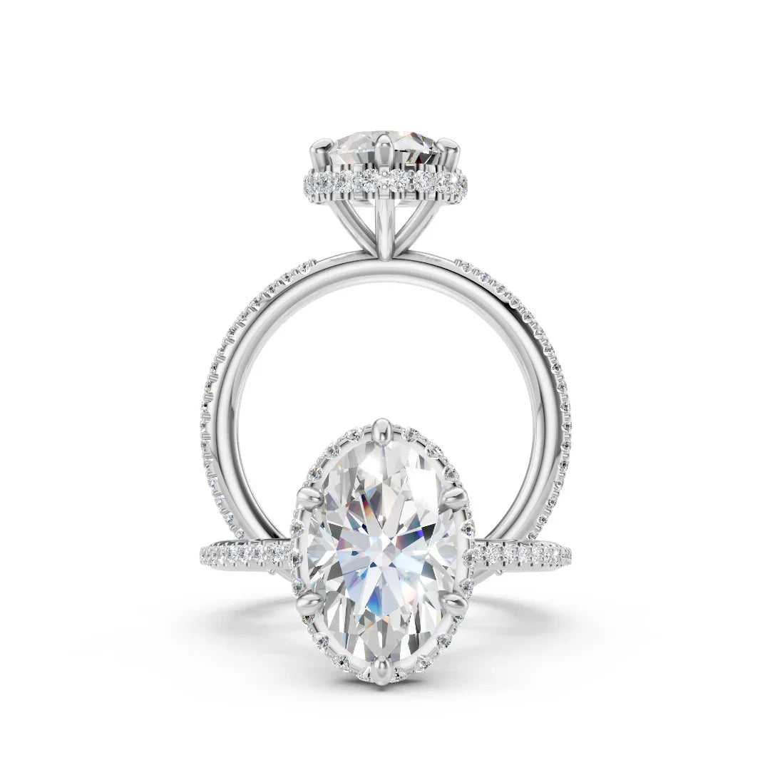 Oval diamond engagement ring with pavé band and halo setting on white background