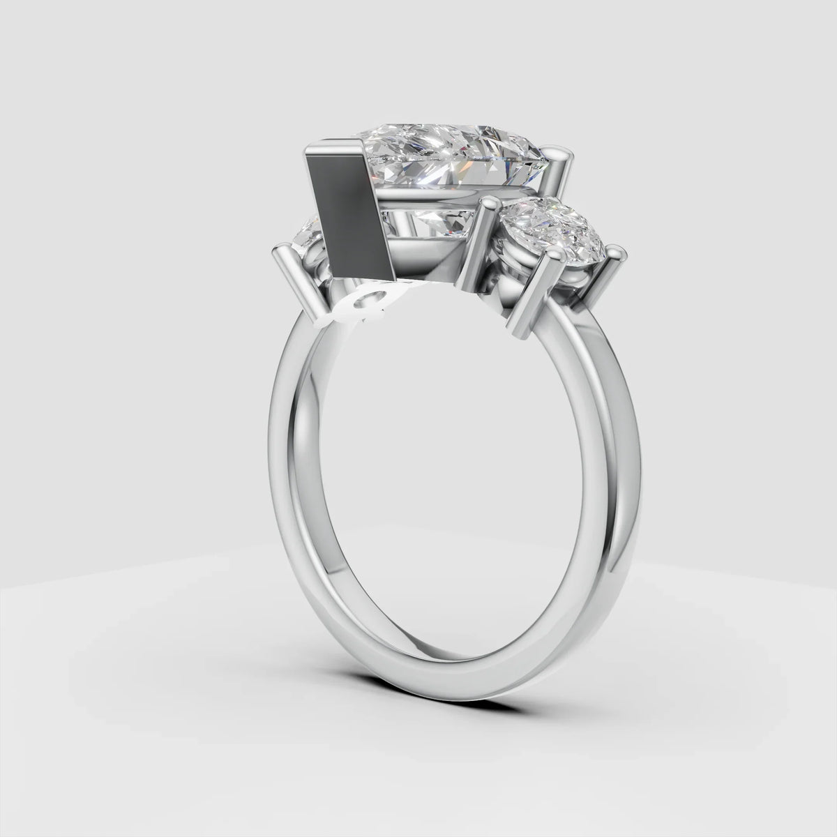 Three-stone diamond engagement ring with white gold band on gray background