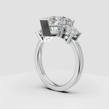 Three-stone diamond engagement ring with white gold band on gray background