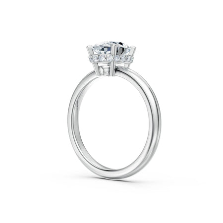 Side view of a solitaire diamond engagement ring with pavé halo on white gold band