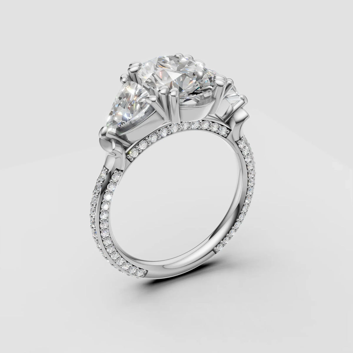 Three-stone diamond engagement ring with pavé band in white gold