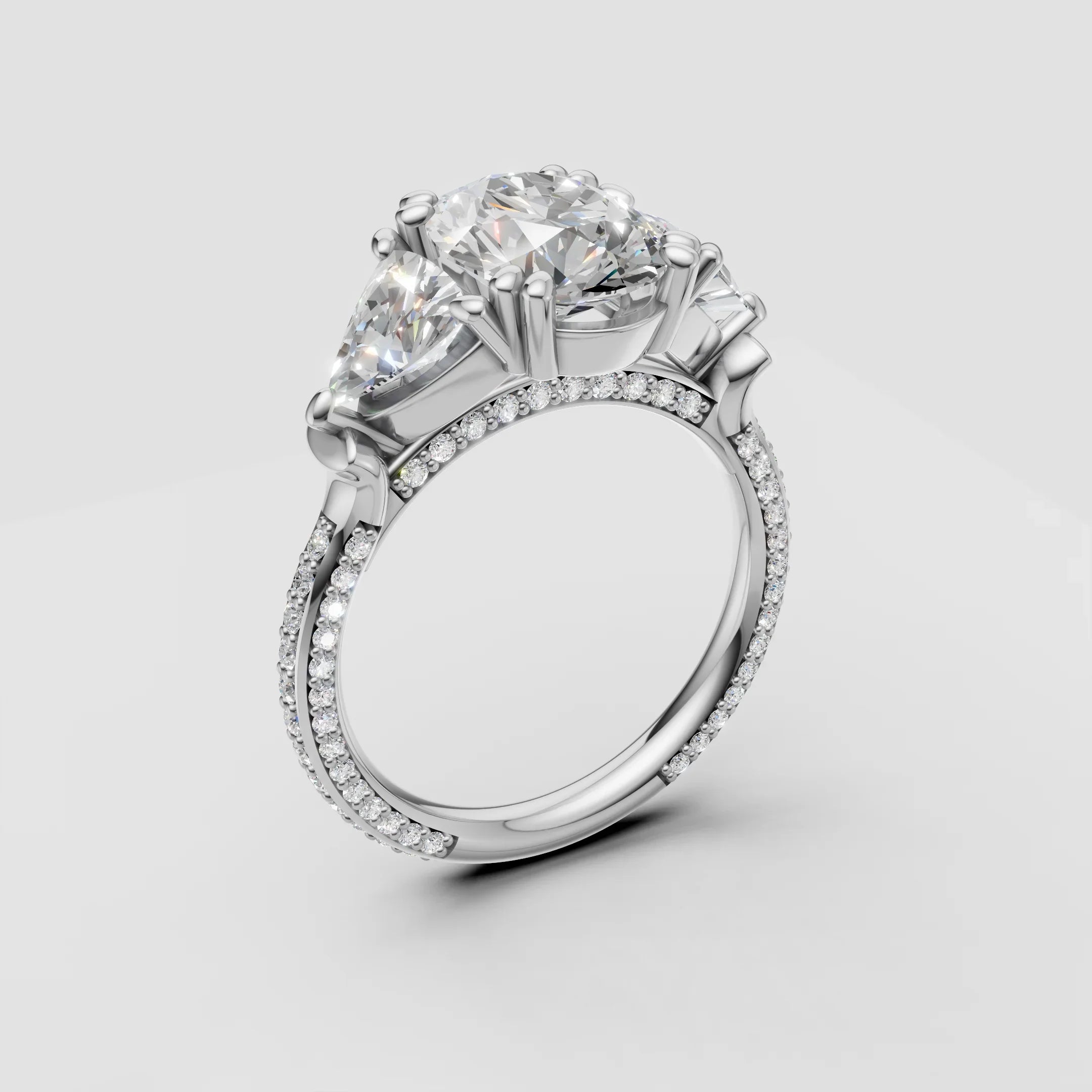 Three-stone diamond engagement ring with pavé band in white gold