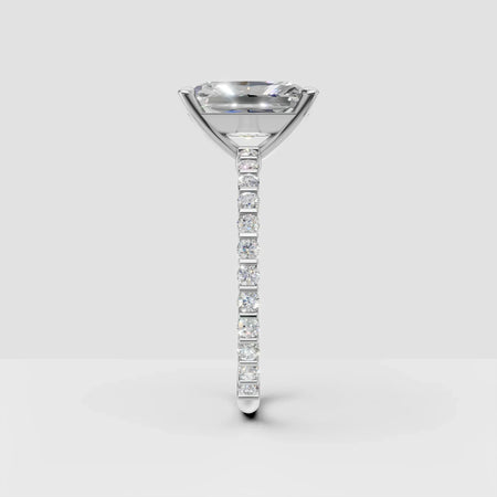 Side view of a white gold engagement ring with a solitaire diamond and pavé band
