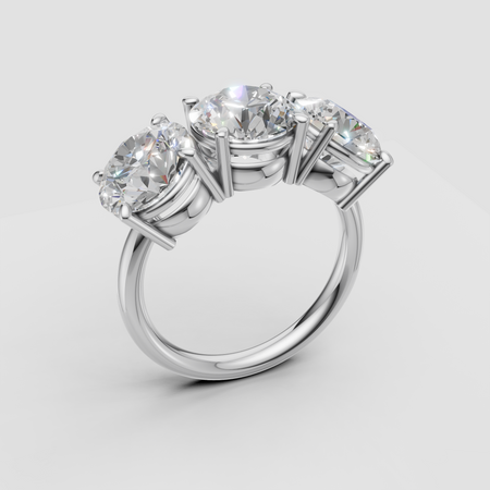 Three stone diamond engagement ring in white gold setting on light background