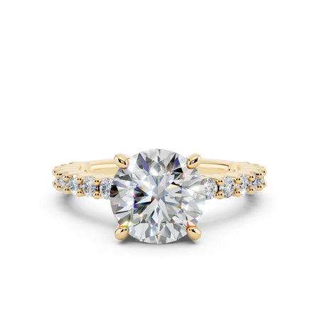 Round brilliant cut diamond engagement ring with pavé yellow gold band