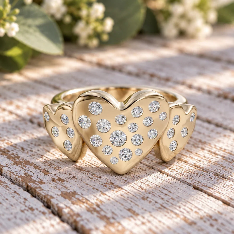 Gold heart-shaped ring with multiple inset diamonds on a rustic wooden surface