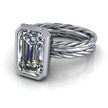 Emerald cut diamond engagement ring with twisted white gold band on white background
