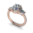 Rose gold three stone moissanite engagement ring with oval center and trapezoid side stones